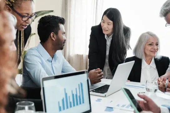 Trabalhadores de instituição de pagamento, analisando gráficos seus clientes enquanto debatem números.