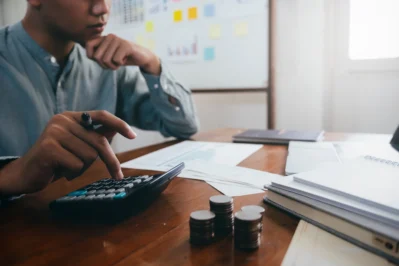 Pessoa analisando documentos e finanças, pensando em como saber se o boleto é falso.