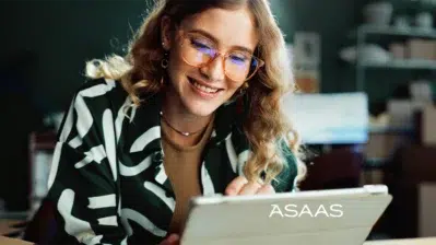 Mulher olhando para baixo usando computador pesquisando as taxas asaas.