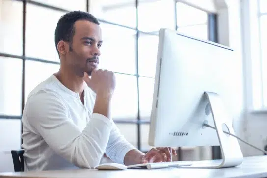 Empreendedor mexendo no computador, pesquisando se existem plataformas de pagamentos com webhooks no Brasil